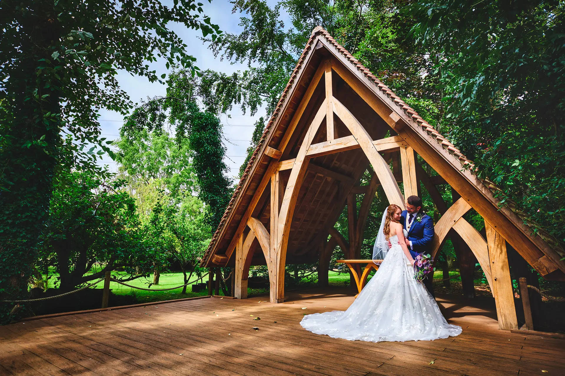 Bride and groom under The Spinney outdoor ceremony space at Rivervale Barn