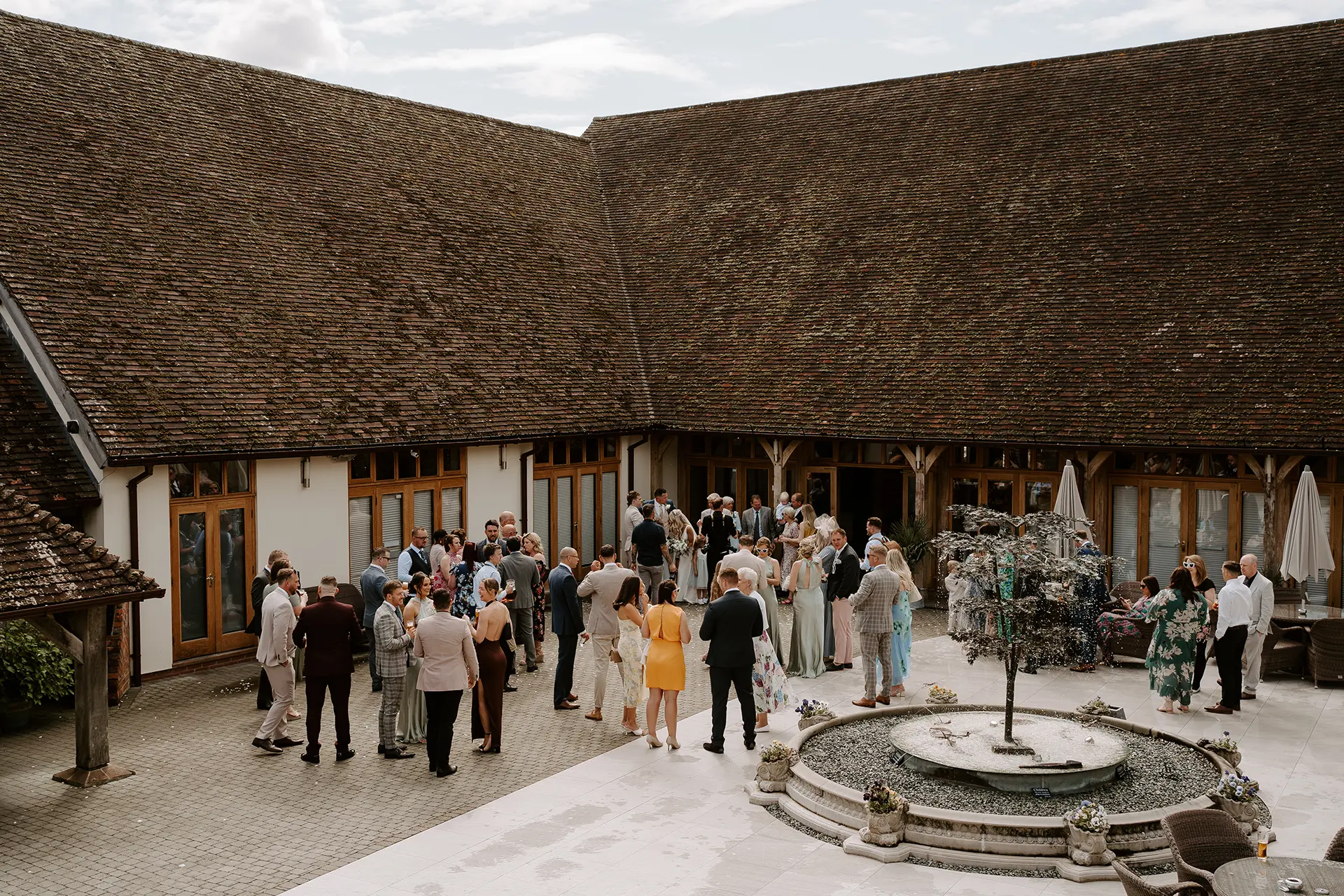 Wedding guests at a drinks reception in Rivervale Barn's Courtyard