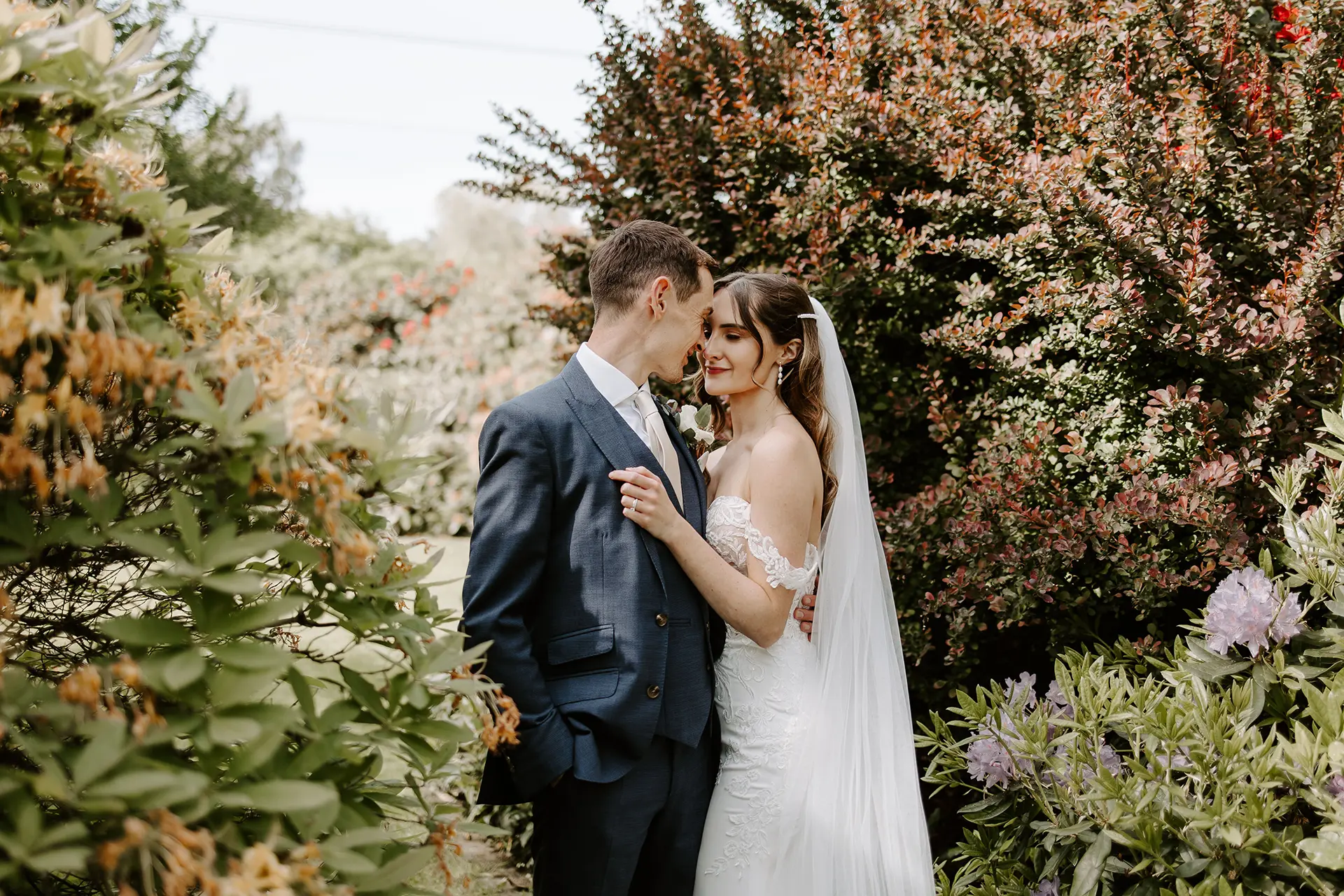 Wedding couple posing for a photo in the gardens at Rivervale Barn