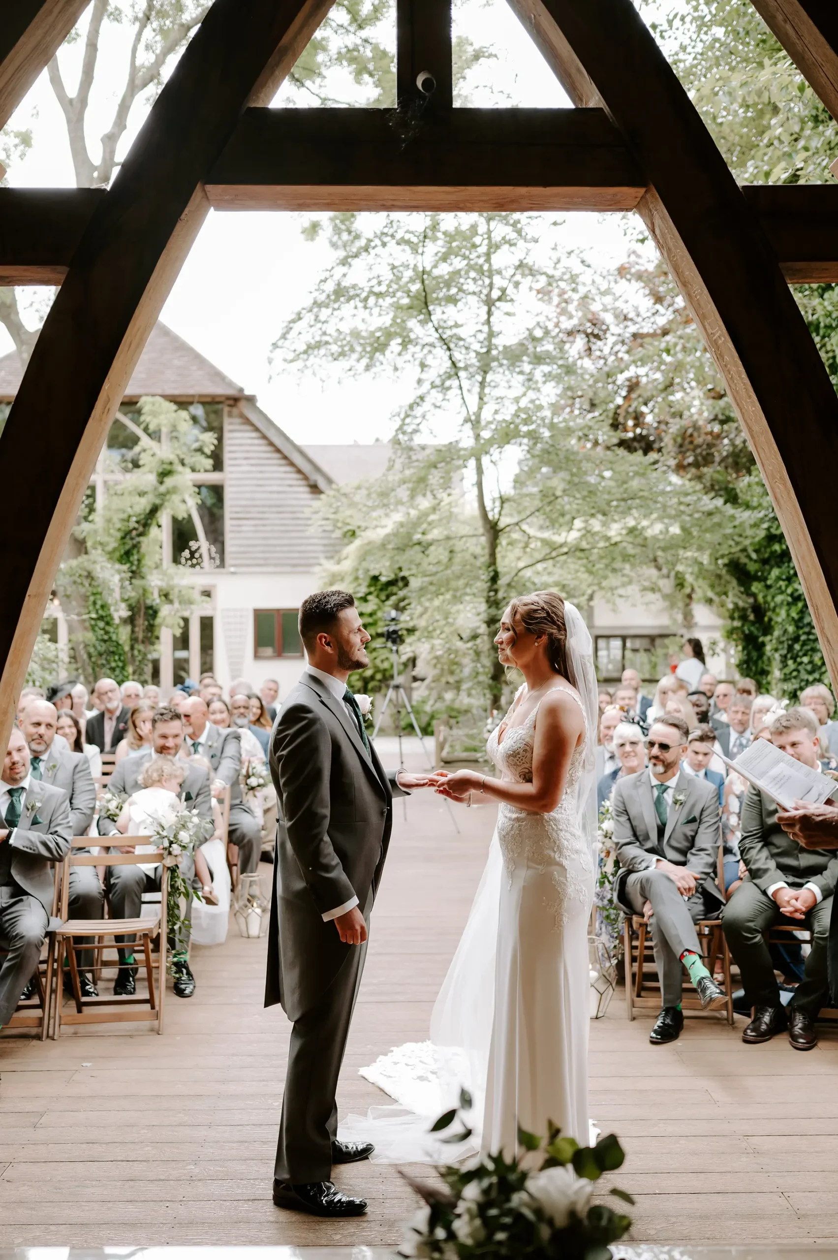 Couple getting married in The Spinney outdoor wedding ceremony space at Rivervale Barn