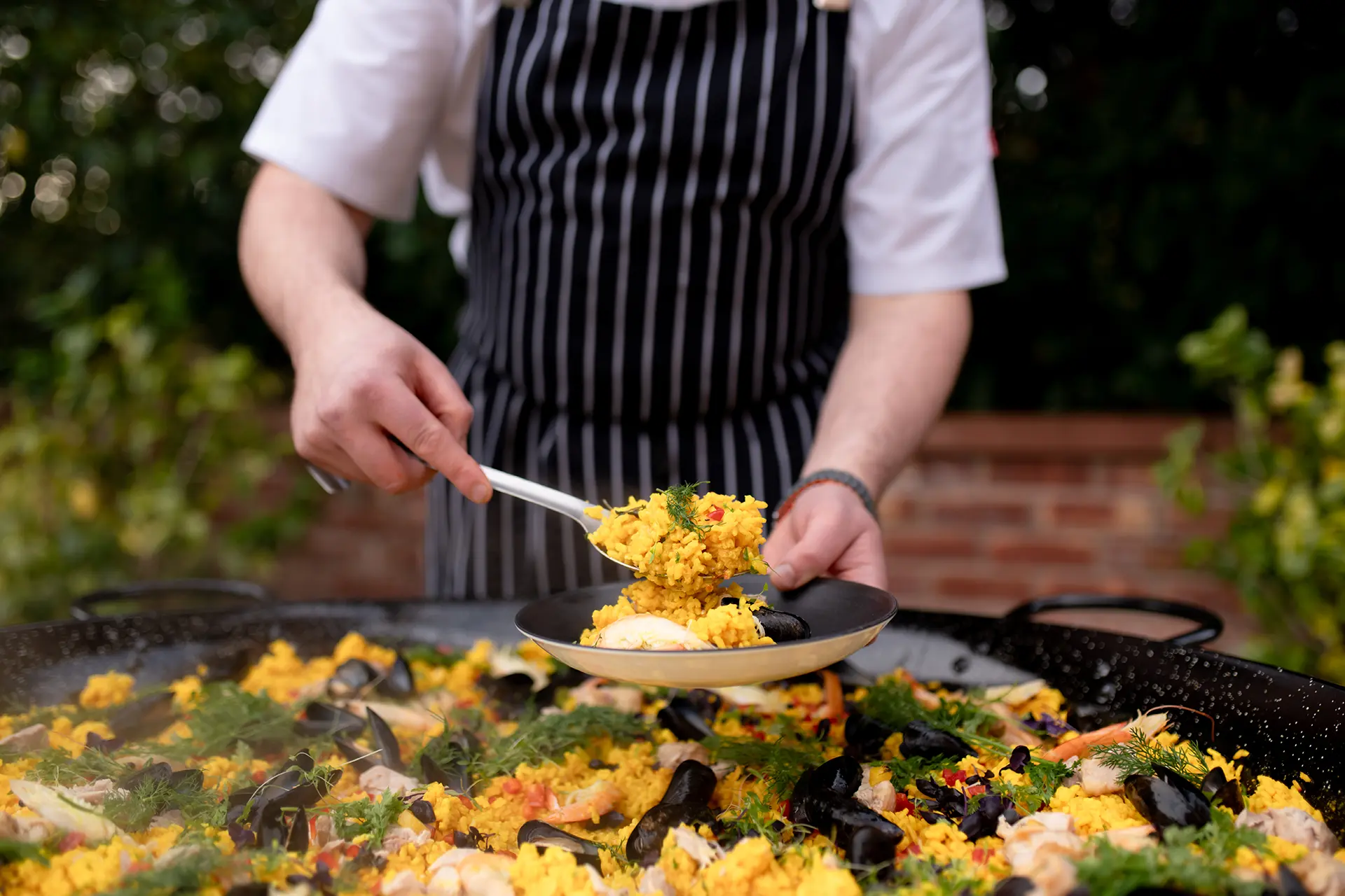 Paella being served from a big wok from Rivervale Barn's outdoor kitchen