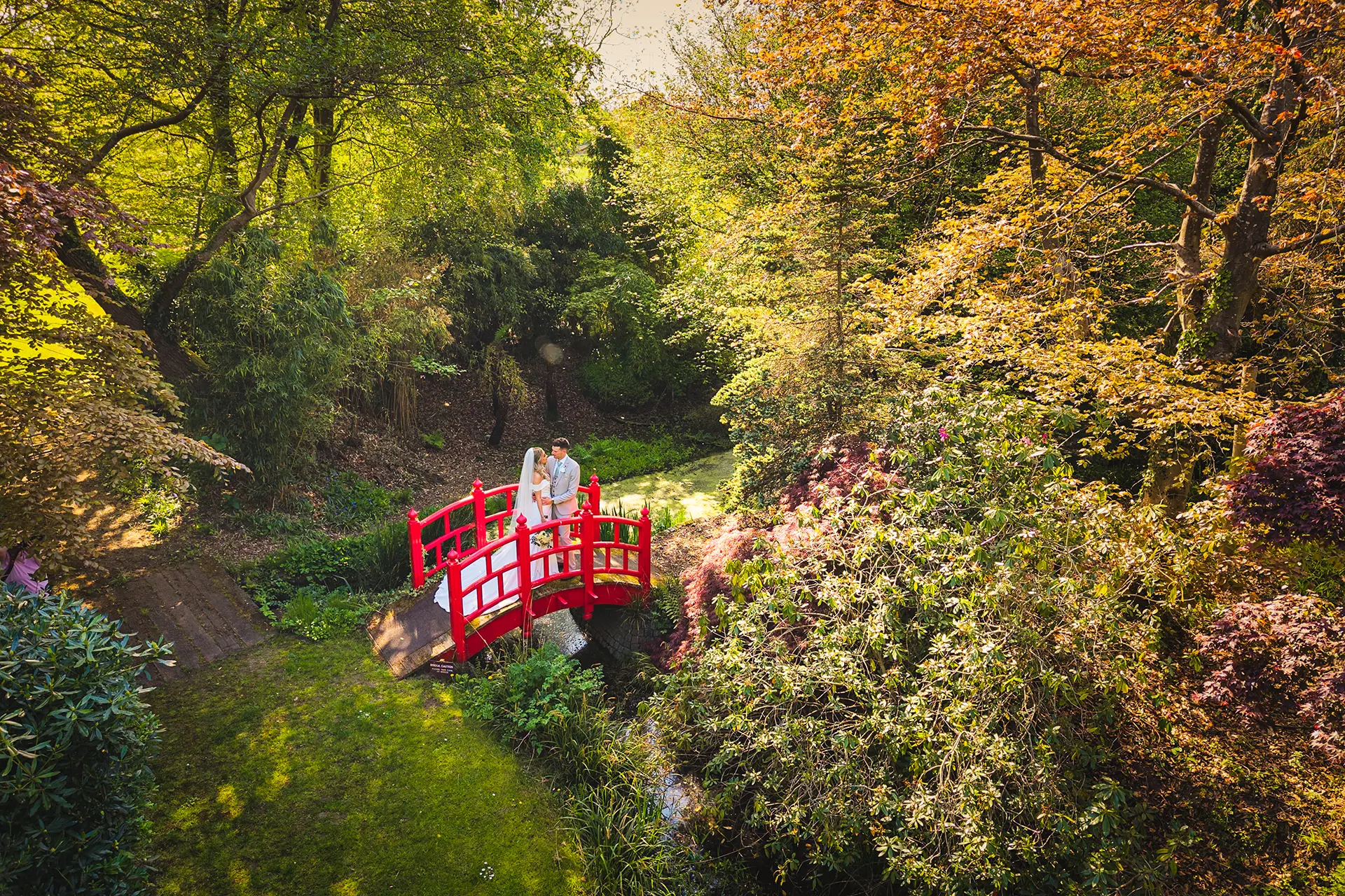 Bride and groom on the bridge in Rivervale Barn’s gardens