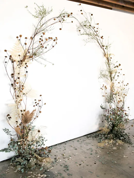 A white wedding arch perfect for autumn and winter, complete with falling petals