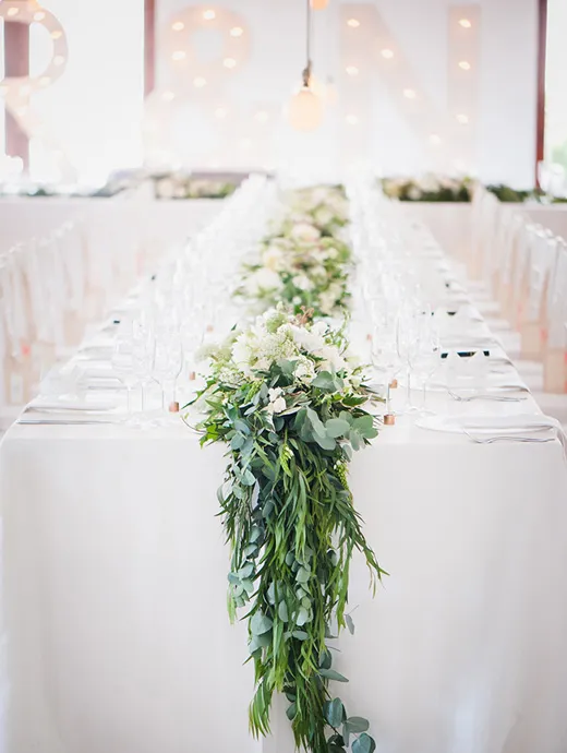 A stunning table décor piece in leafy greens and blush pinks