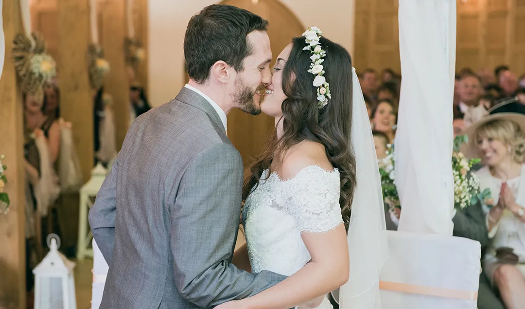 the new mr and mrs shared a kiss during their autumnal decorated wedding ceremony