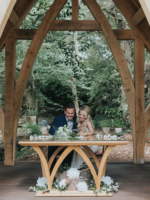 Newlyweds posing in The Spinney, Rivervale Barn’s stunning outside ceremony space
