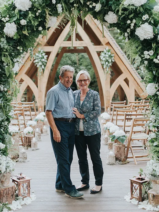 Venue owners John and Moyra pose proudly outside The Spinney, Rivervale Barn’s outside ceremony area