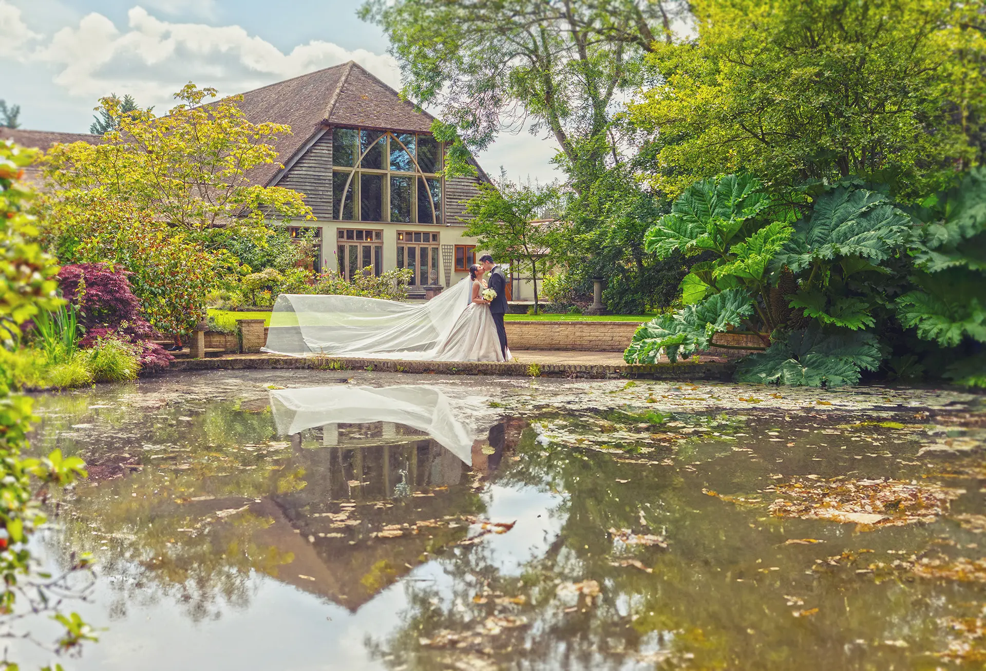 Couple getting their wedding photos taken outside Rivervale Barn venue
