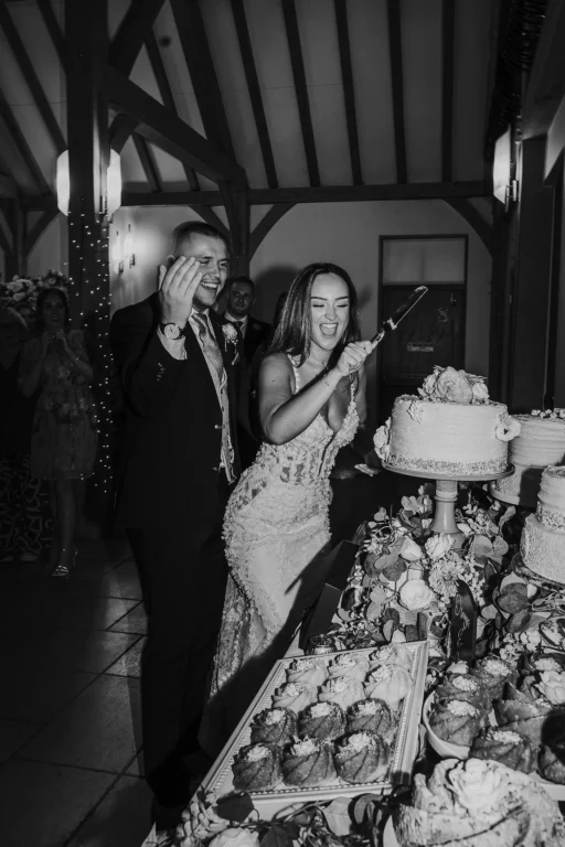 Couple cutting their cake at a wedding at Rivervale Barn