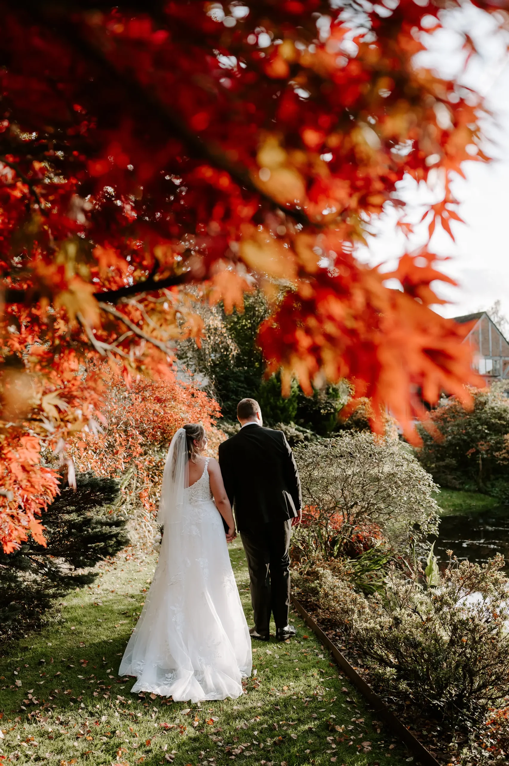 Couple walking through Rivervale Barn's garden in autumn