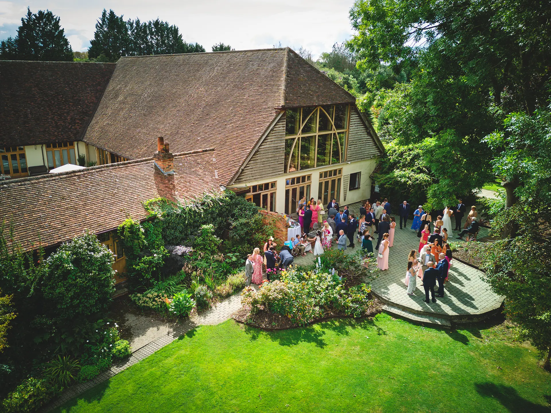 Wedding guests at an outdoor drinks reception at Rivervale Barn